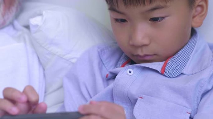 在智能手机上玩游戏的亚洲男孩