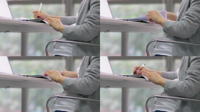 中国孕妇办公室妇女在文件上做笔记