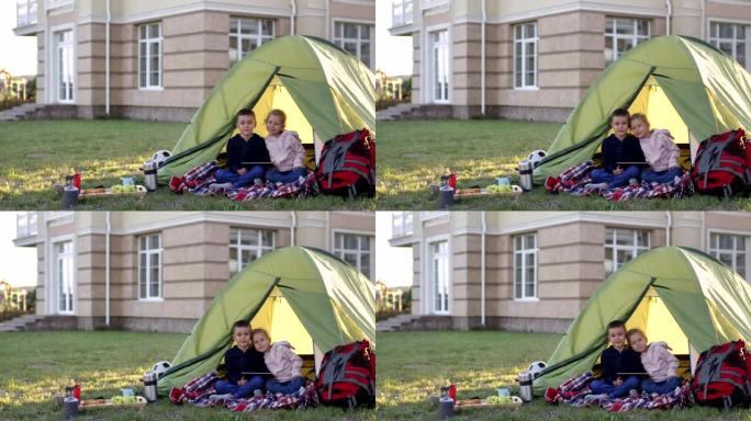 友好的高加索兄弟姐妹在露营帐篷里摆姿势拍照
