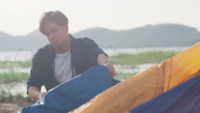 年轻的亚洲露营者在海边户外搭建帐篷露营装备。