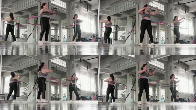 超重的女人在健身馆玩呼啦圈。