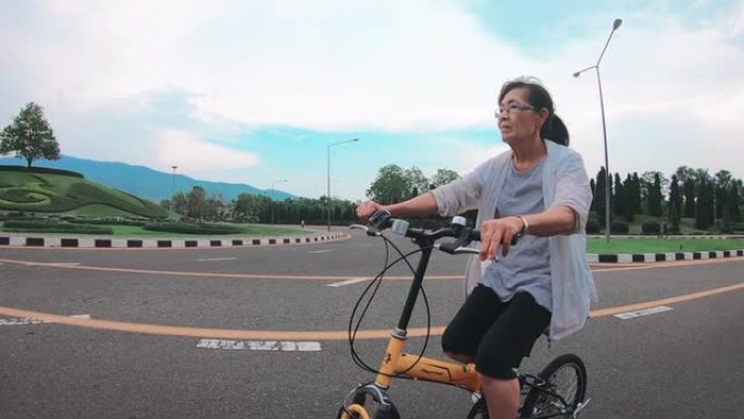 资深亚裔女子在公园骑脚踏车