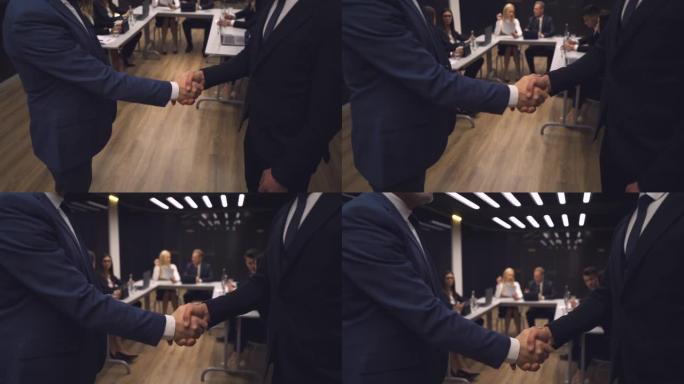 商务人士在会议室握手。慢动作