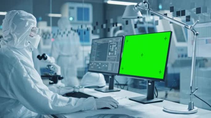 研究工厂洁净室: 穿着工作服和手套的工程师/科学家的特写镜头使用显微镜，计算机显示色度键/绿屏显示。