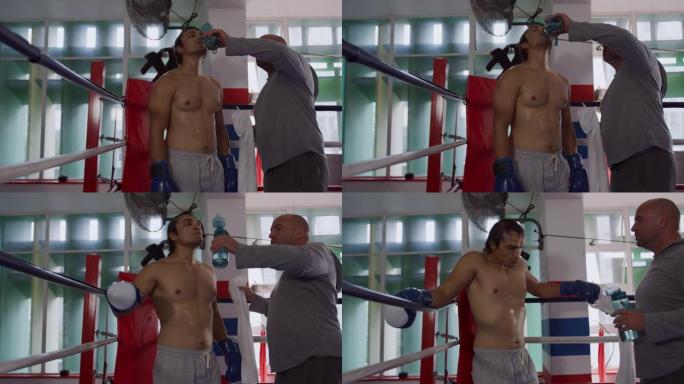 高加索教练在拳击场上给高加索运动员喝水