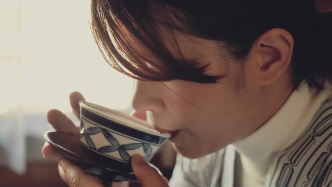 亚洲旅游妇女在日本的小屋喝热茶