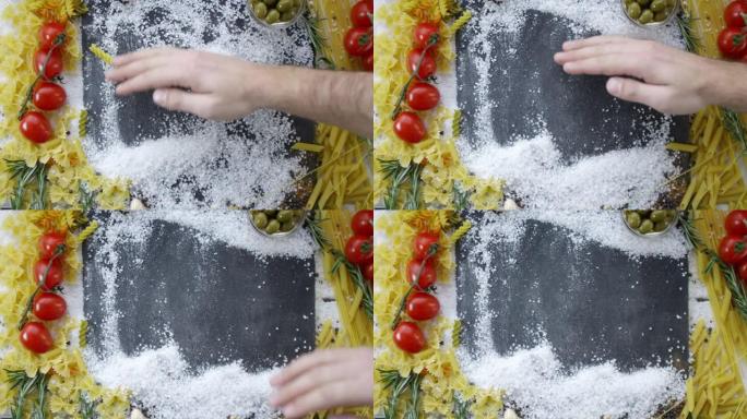 厨师从黑砧板中心移动盐的手