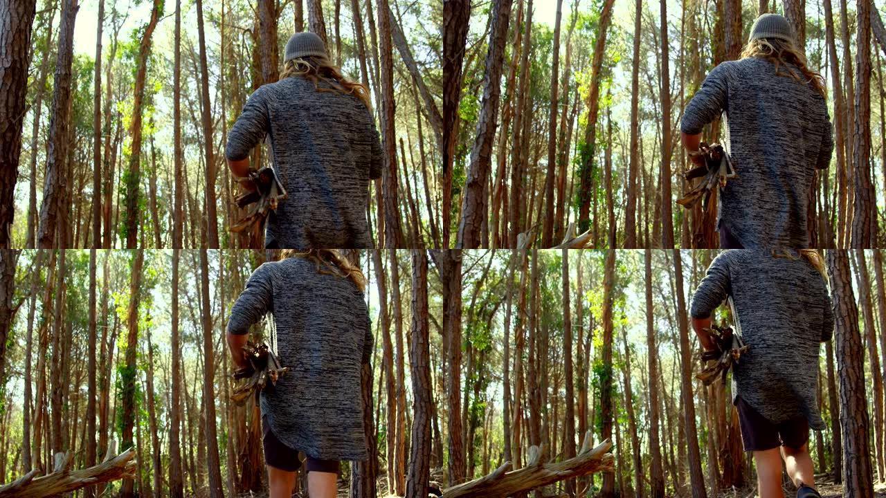 用木棍在森林里行走的人的后视图4k