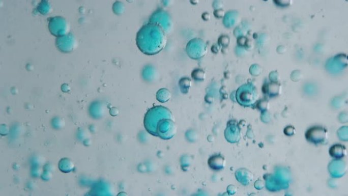 用显微镜分析液体中蓝色微粒分子的慢动作宏观，用于科学实验室的护肤美容化妆品研究