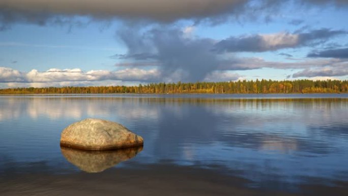 芬兰禅宗景观。湖中流动的水。阳光和水反射在石头上。风景如画的天空，背景是美丽的云彩。4K