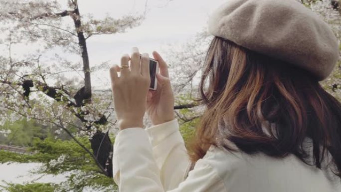 女人用智能手机在山腰拍照