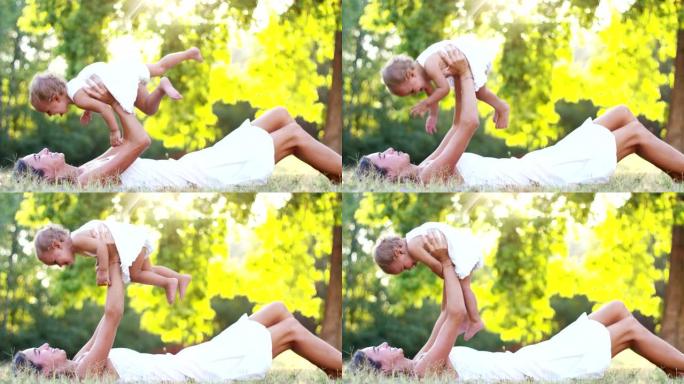 妈妈和小女孩在大自然中快乐地玩耍，母亲将婴儿抱在怀里放松，高兴地在阳光下一家人在一起