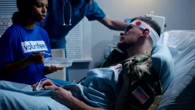 护士在病床上给受伤的士兵喂奶