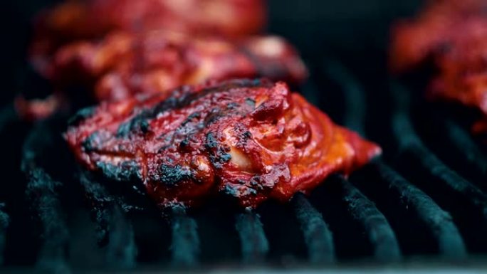 在烧烤烤架上烹饪坦杜里鸡肉。