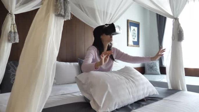 在卧室里使用VR眼镜的亚洲女性