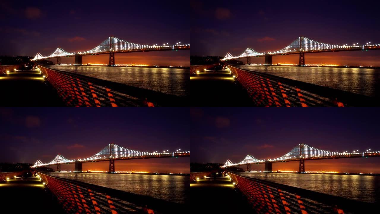 晚上旧金山的照明桥。行人的彩色路径。天际线。河。