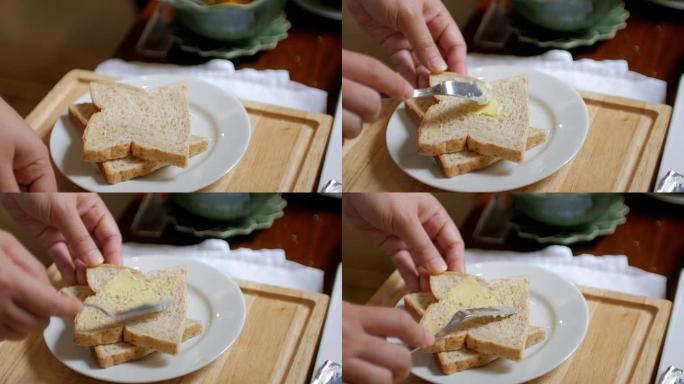 将黄油撒在一片面包上作为早餐