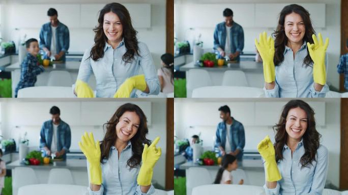 在慢动作的家庭幸福家庭背景下做家务时，微笑的母亲戴着黄色手套的肖像。