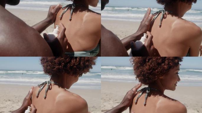 男子在海滩4k的女人肩膀上涂抹防晒霜