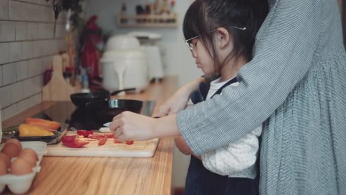 可爱的小女孩和妈妈在家做饭