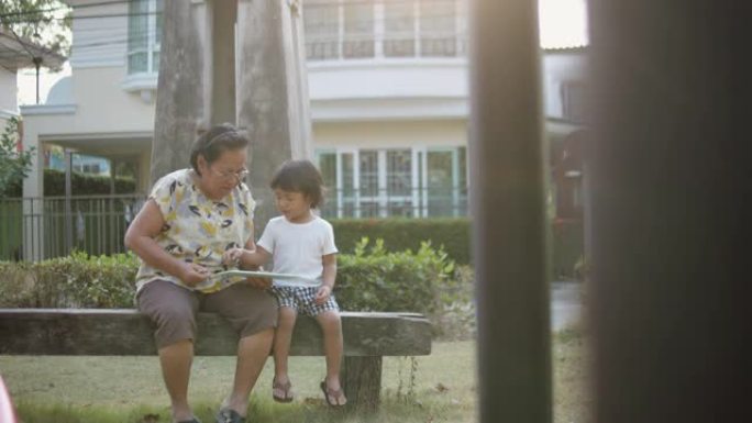 孙子和祖母在公园的长凳上接吻。