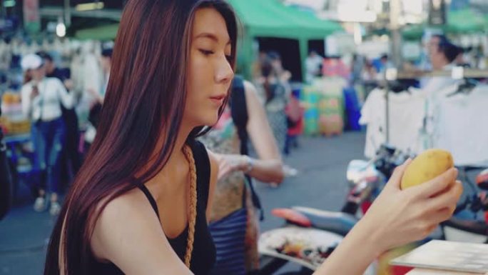 在考山路街上买果汁的亚洲妇女。