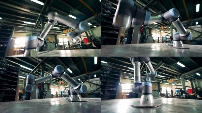 在工厂工作台上工作时，一个金属臂会移动。
