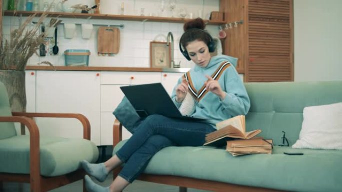 年轻女子在新型冠状病毒肺炎大流行期间在家工作的视频中引用书籍。