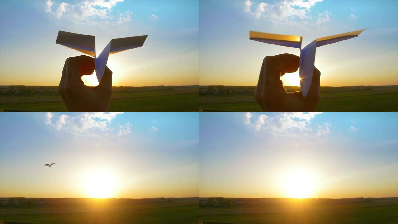 手在日落背景上向天空发射纸飞机