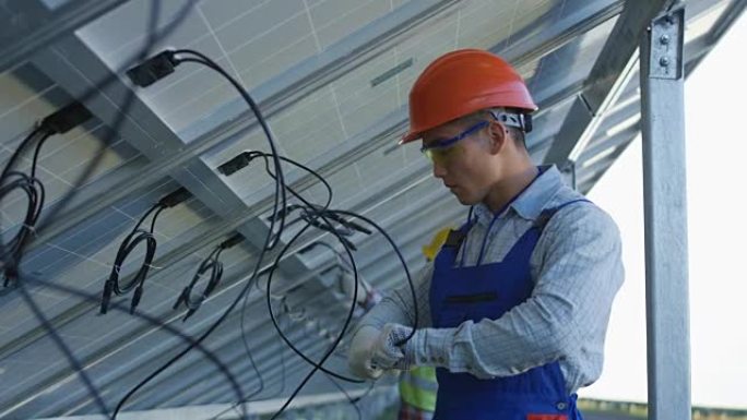 工人连接太阳能电池板的电线