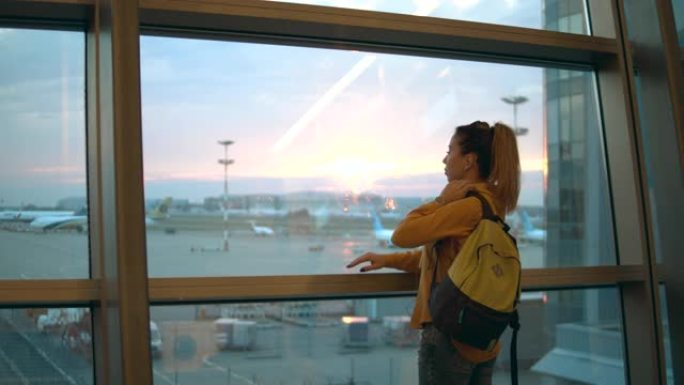 可爱的女士正在观察机场的景色