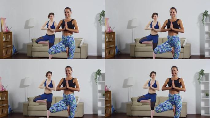 两个女人在练习瑜伽时摆树姿势并微笑