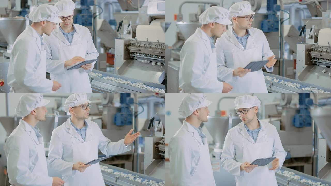 两名年轻的男性质量主管或食品技术人员正在饺子食品工厂检查自动化生产。员工使用平板电脑工作。他们穿着白