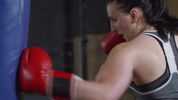 女拳击手在健身房打重包