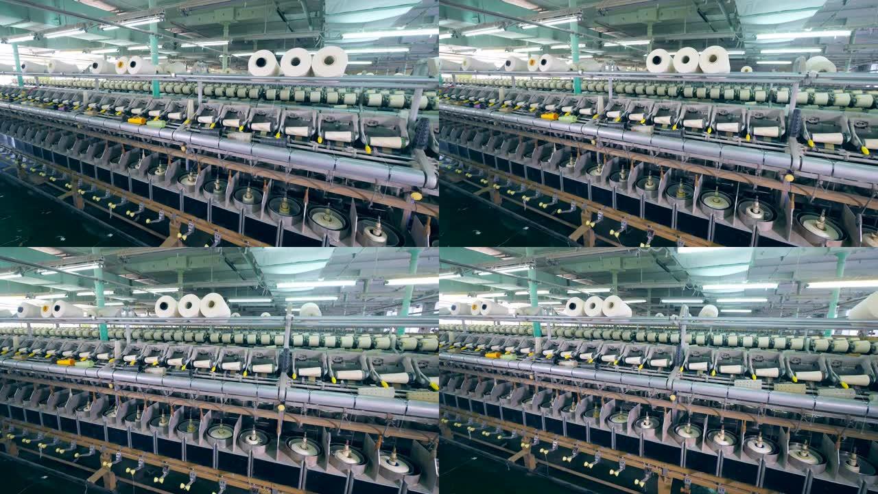 成排的线轴，在纺织厂的机器上旋转。