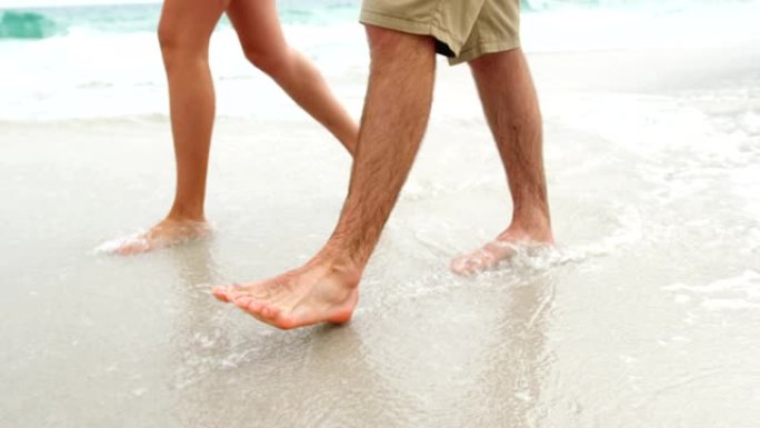低矮的情侣赤脚走在海滩4k