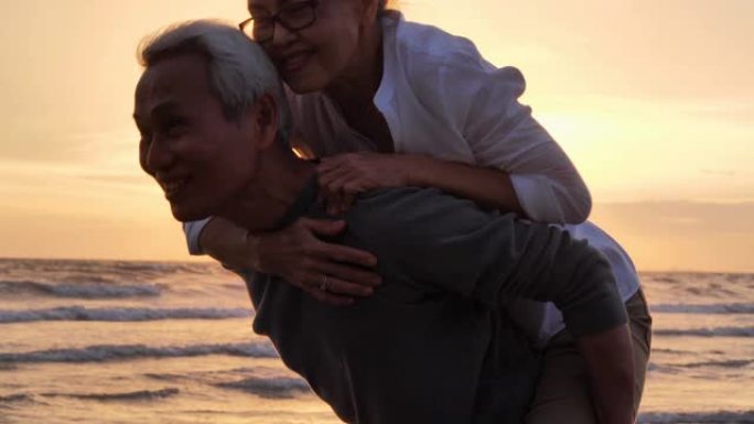 老年夫妇在海边放松。老年假期，假期。退休假期概念，快乐的成熟退休夫妇在海滩上享受美丽的日落，老年夫妇