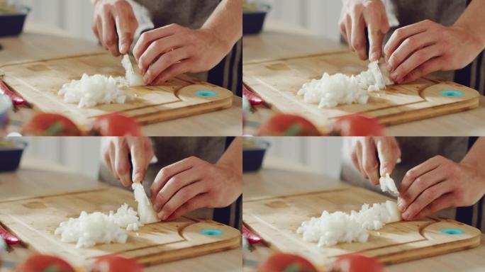 一名男子用锋利的菜刀切碎洋葱的特写镜头。在现代厨房准备健康的有机餐。天然清洁饮食和健康的生活理念。