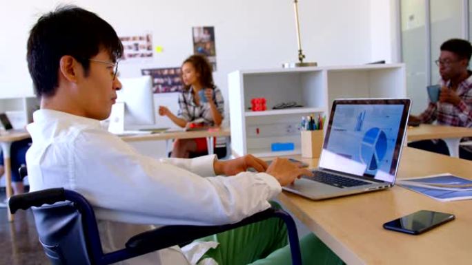 现代办公室4k残疾亚洲男性行政人员在办公桌上使用笔记本电脑