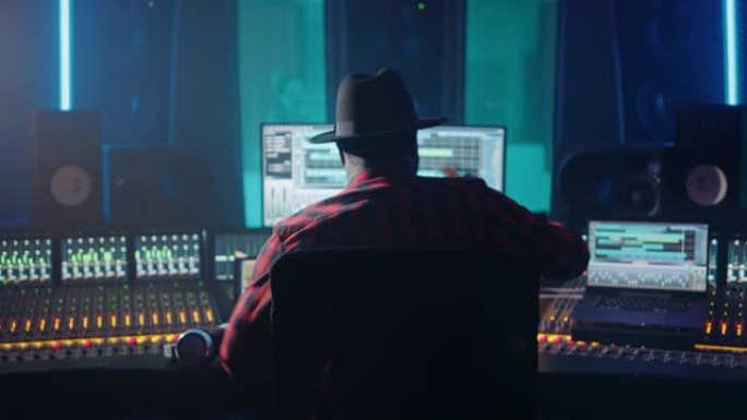 艺术家，音乐家，音频工程师，音乐唱片工作室的制作人，使用带有计算机屏幕的控制台，显示带有歌曲播放的软