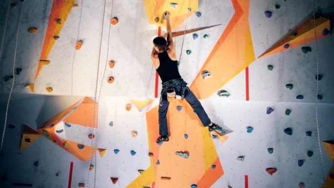 一个人在攀岩墙上练习，特写。
