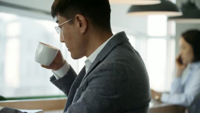 商人喝茶和使用笔记本电脑