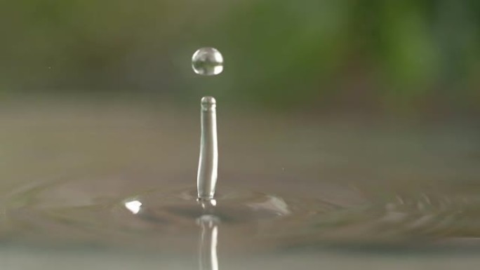 慢动作: 微小的透明水滴落入充满水的厨房水槽中。