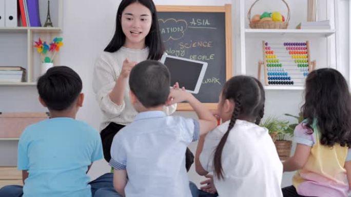 老师在技术课中在数字平板电脑上教学生。快乐的孩子在课外课堂上学习使用平板电脑。回到学校，团队合作，领