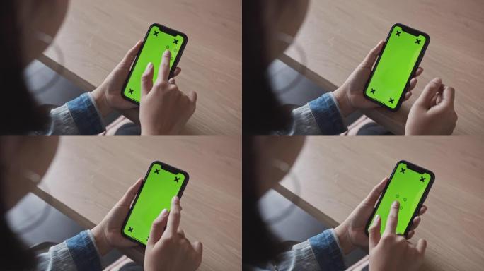 4K UHD慢动作: 女人在家使用、滚动和查看带色度键的智能手机绿屏