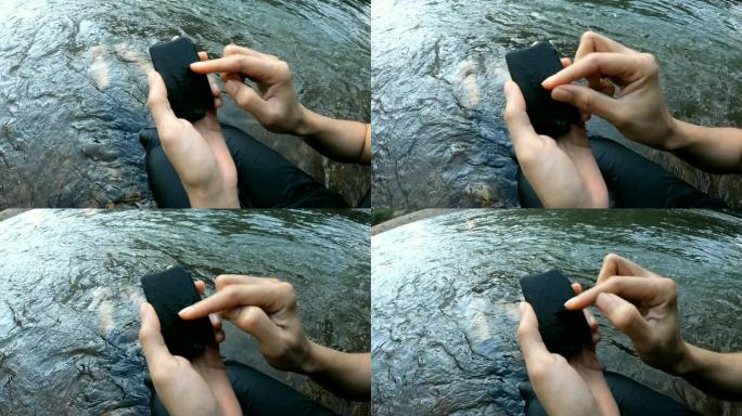 手在石头上滑动假装用智能手机。