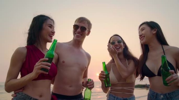 慢动作: 晚上日落时，一群朋友在海滩和海上喝啤酒，庆祝和欢呼瓶啤酒。朋友海滩派对喝酒敬酒庆祝和友谊概