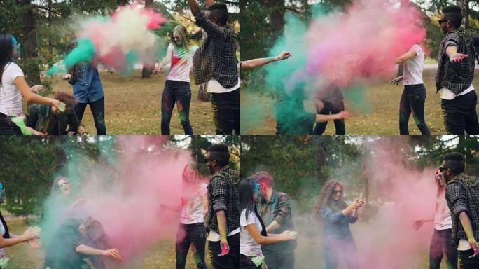 快乐的学生慢动作在洒红节上互相扔五颜六色的粉末涂料，在公园户外笑着享受快乐的传统。