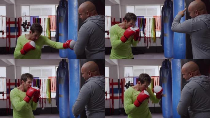 高加索人在拳击馆里用背包和教练一起使用