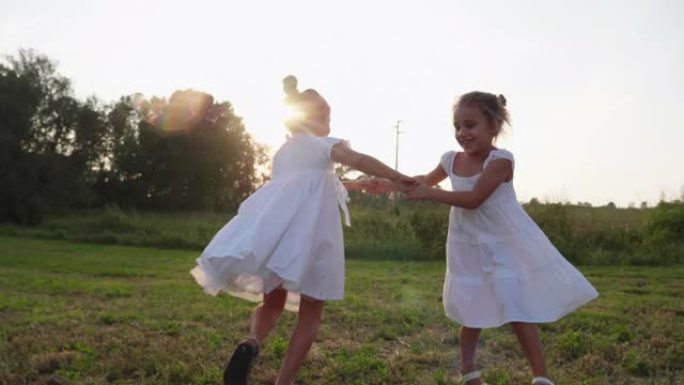 两个可爱的快乐无忧无虑的小女孩的真实照片姐妹们在阳光明媚的日子里拥抱和享受她们在大自然中的时光